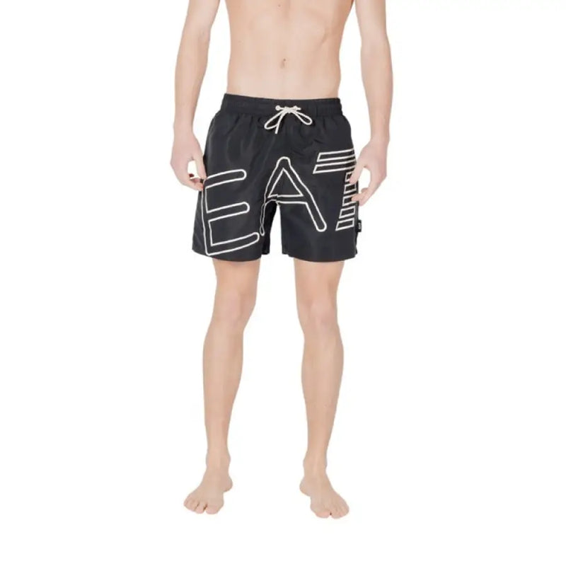Black swim trunks featuring a prominent white logo for men’s beachwear