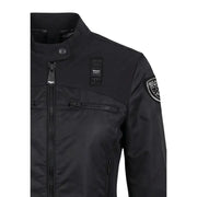 Black Bianca USA trägt einen schwarzen Damenblazer von Blauer mit Rollkragen, Vordertaschen und Reißverschluss.