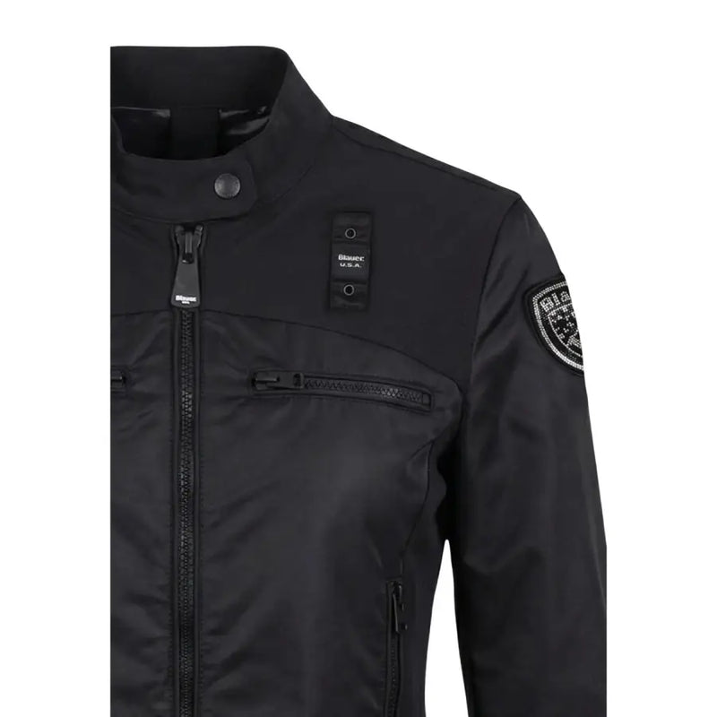 Black Bianca USA trägt einen schwarzen Damenblazer von Blauer mit Rollkragen, Vordertaschen und Reißverschluss.