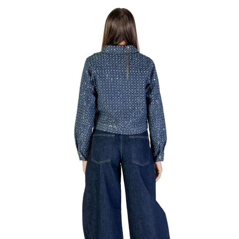 Woman modeling a dark blue cotton blazer with white pattern and wide-leg jeans for fall winter fashion