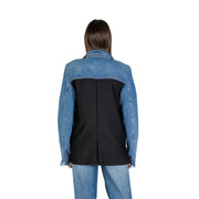 Blue long sleeve blazer for women in blue and black denim blend with structured back panel and front pockets visible from back side
