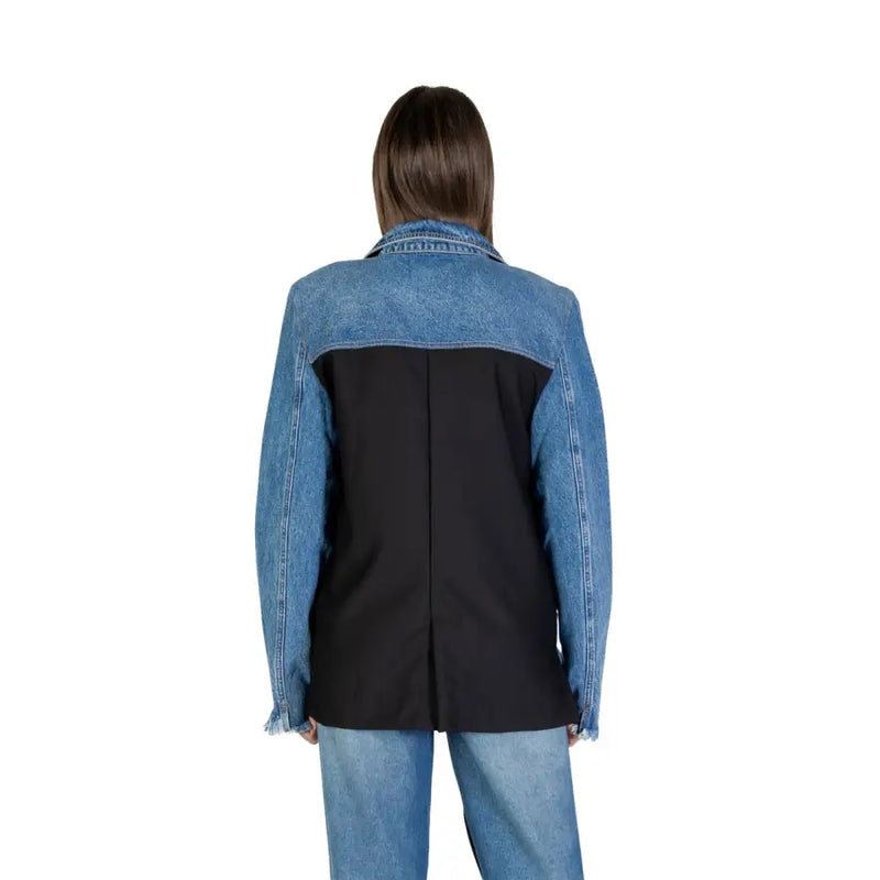 Blue long sleeve blazer for women in blue and black denim blend with structured back panel and front pockets visible from back side