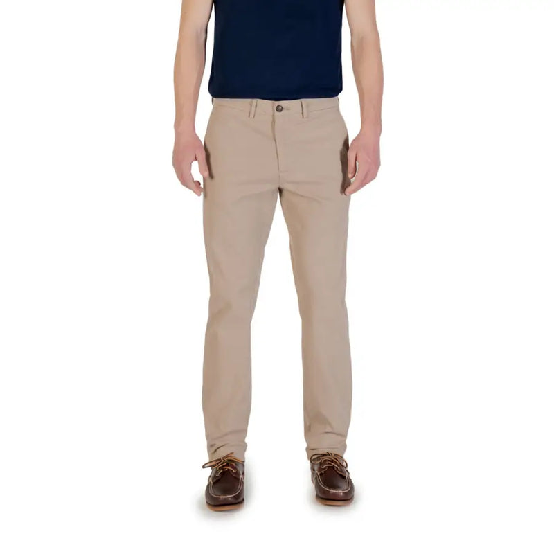 Men’s beige chino trousers paired with navy polo shirt and brown boat shoes for spring summer fashion