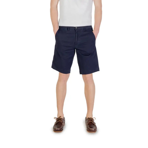 Navy blue cotton shorts with brown leather boat shoes and a white tank top.