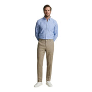 A man wearing borghese men trousers camel 100% linen paired with a light blue button-down shirt spring summer attire