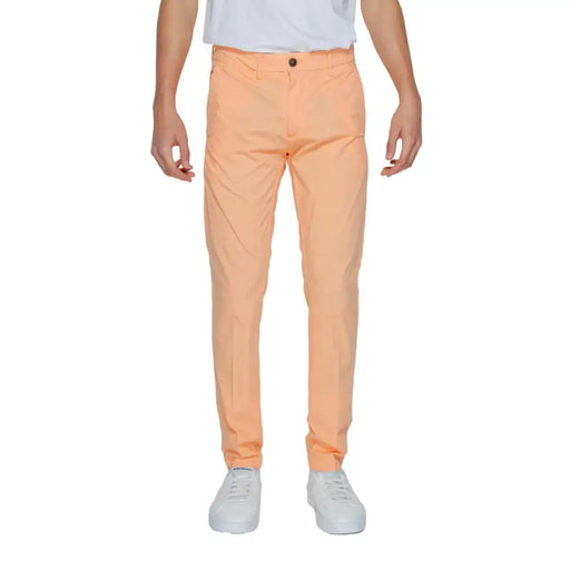 Eine Borghese Herrenhose in Pfirsichfarbe, schmal geschnitten, mit dezenter Struktur und einem einzelnen Knopfverschluss.