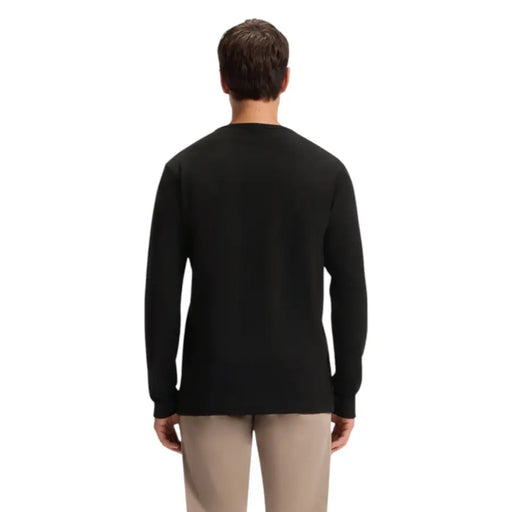 Black long-sleeved crew neck sweater with ribbed cuffs and hem, likely made of cotton or a similar soft fabric.