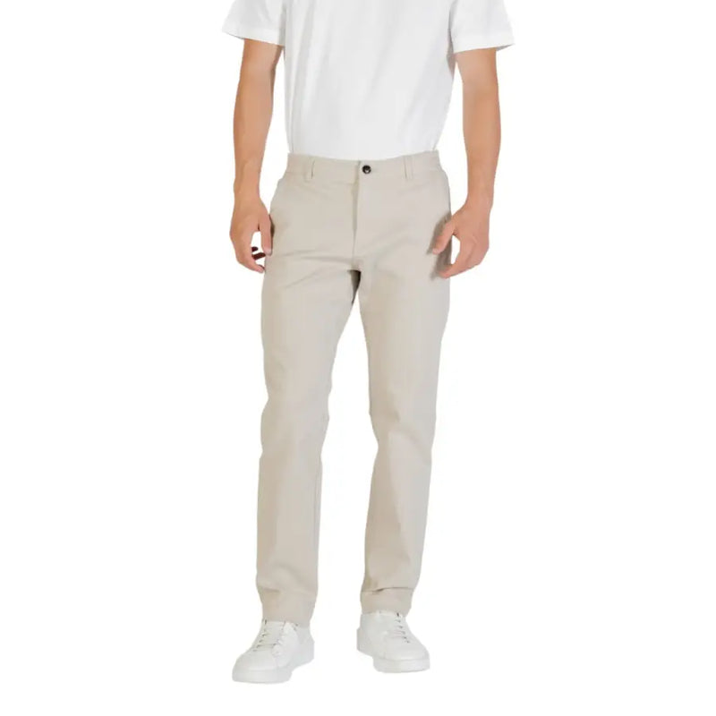 Men’s light beige slim-fit chinos with black button and white sneakers for fall and winter