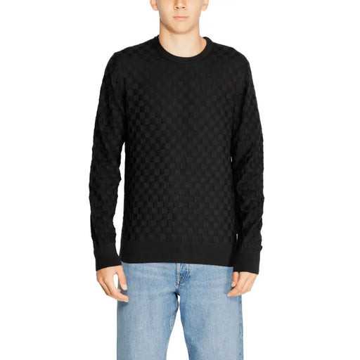 Black quilted sweater with a textured pattern and crew neck.