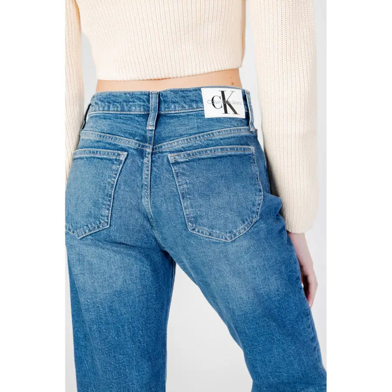 Blue denim calvin klein women’s jeans with worn-out effect featuring a white label at the waistband