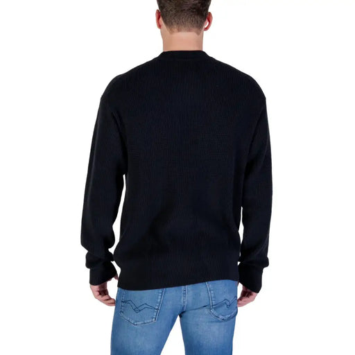 Black ribbed crew neck sweater with jeans and a casual look.