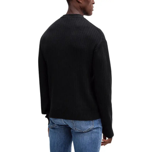 Black ribbed sweater with crew neck and jeans the main object in this image is a black ribbed sweater featuring a crew neckline, paired with blue denim jeans.