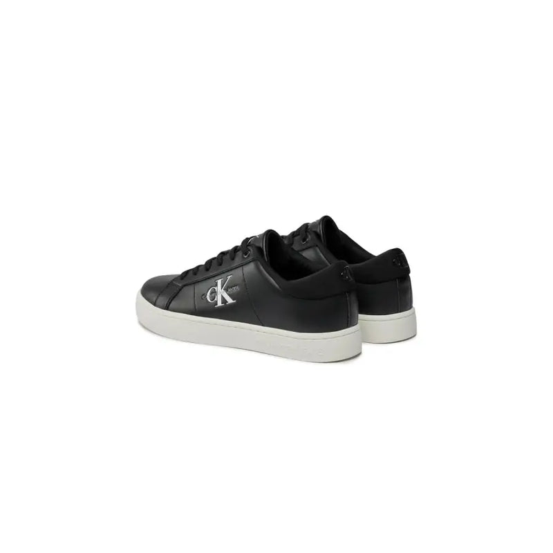Black leather calvin klein sneakers with white soles and monogram logo.