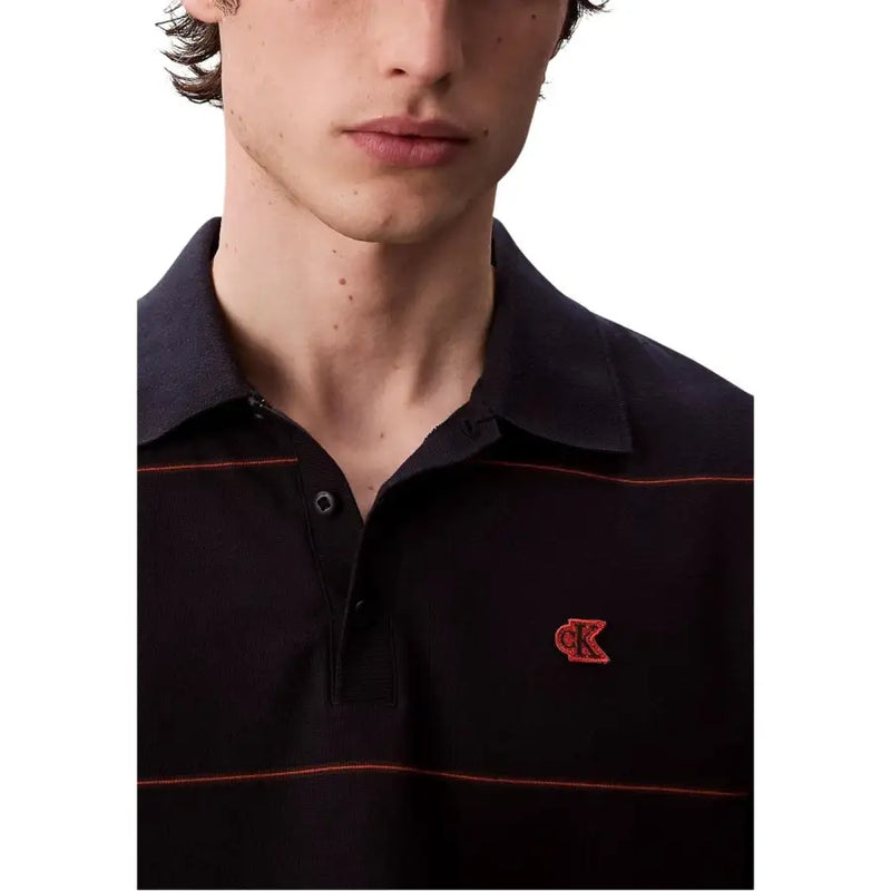 Schwarzes Poloshirt mit roten und weißen Streifen, Calvin Klein Logo.