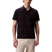 Lacoste Poloshirt mit marineblauen und bordeauxroten Streifen und rotem Krokodillogo.
