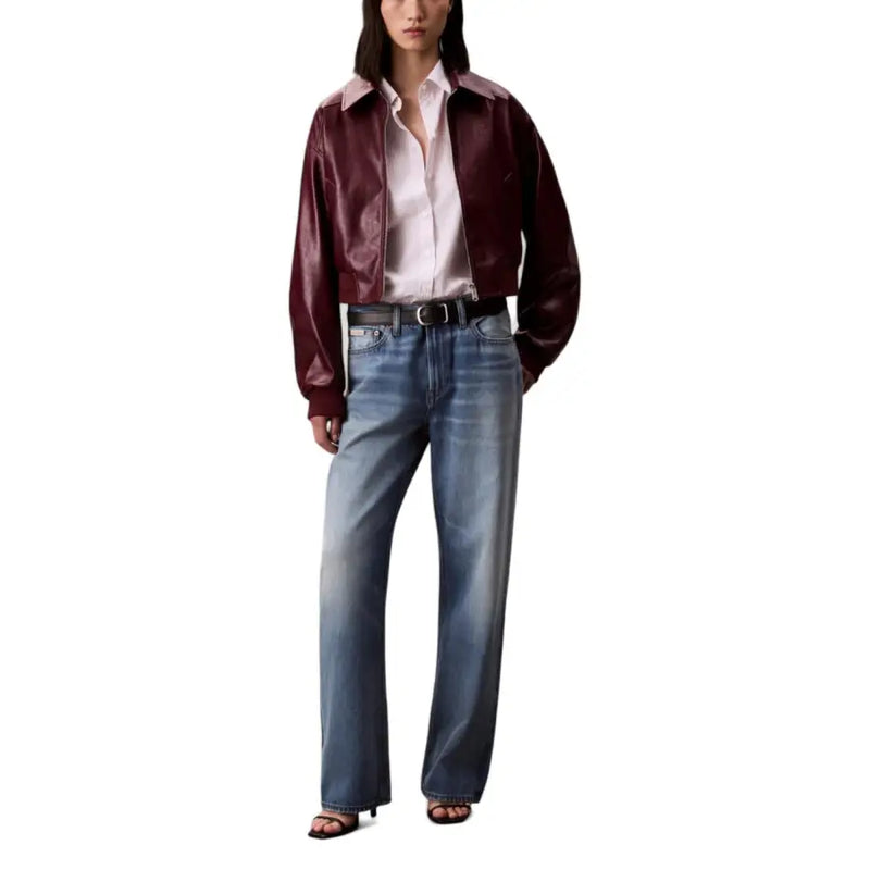 Woman wearing Bordeaux long zip front blazer with white shirt and wide-leg blue jeans