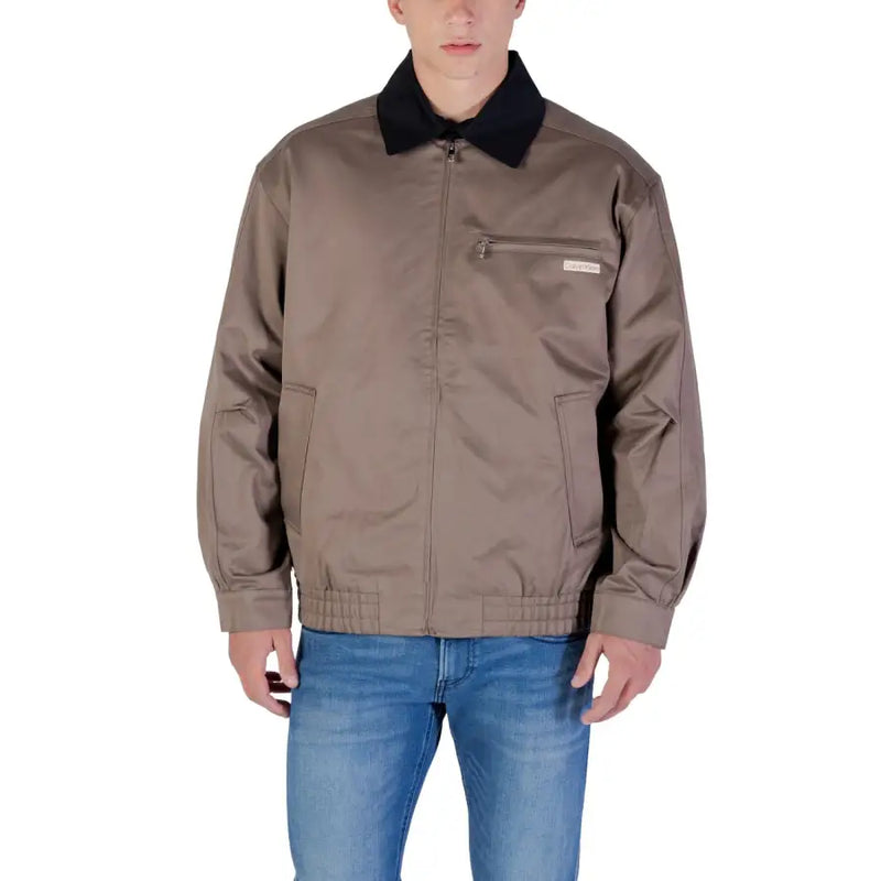 Braune Bomberjacke mit schwarzem Kragen und Taschen, wahrscheinlich aus Nylon oder Polyester.