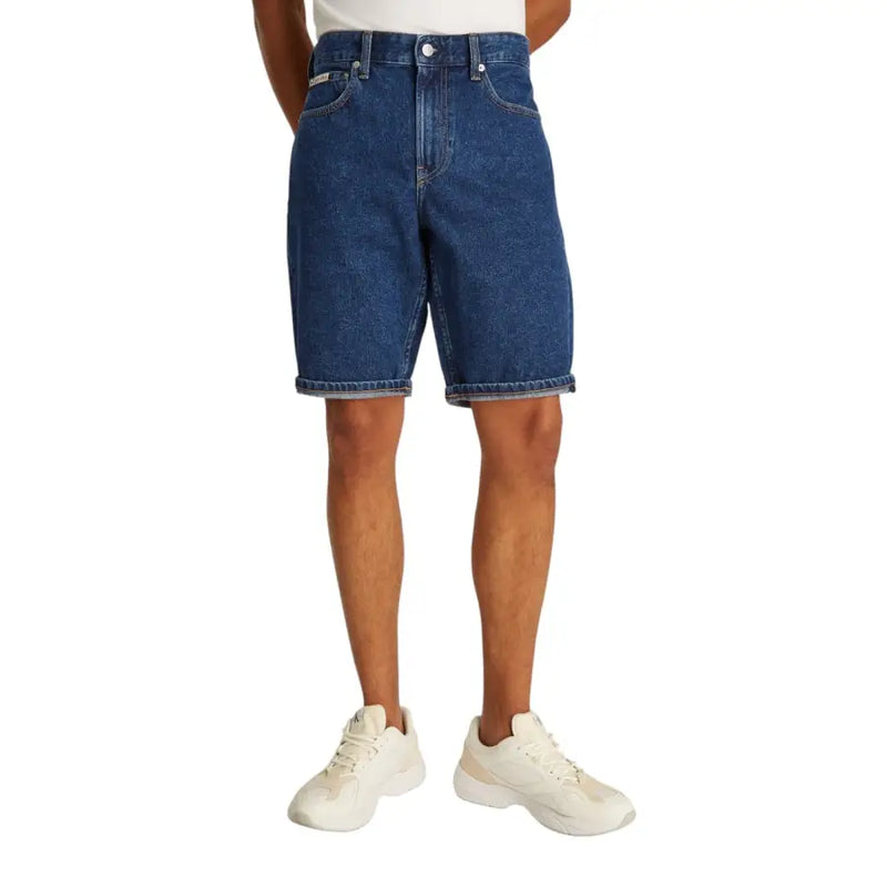 Blaue Jeansshorts mit umgeschlagenem Saum und weiße Sneaker