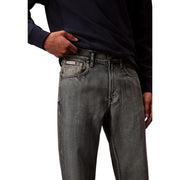 Back side of dark gray denim Calvin Klein jeans with faded wash and visible stitching in cotton blend fabric