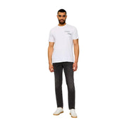 Weißer Calvin Klein t-shirt mit dezentem, schwarzem Logo in Schreibschrift, kombiniert mit beigefarbenen Baumwolljeans im klassischen Schnitt für Herren