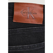 Schwarze, schmal geschnittene Herren-Jeans aus Baumwoll-Denim, die die Rückseite mit einem hellbraunen Lederpatch mit Calvin Klein-Logo zeigt.