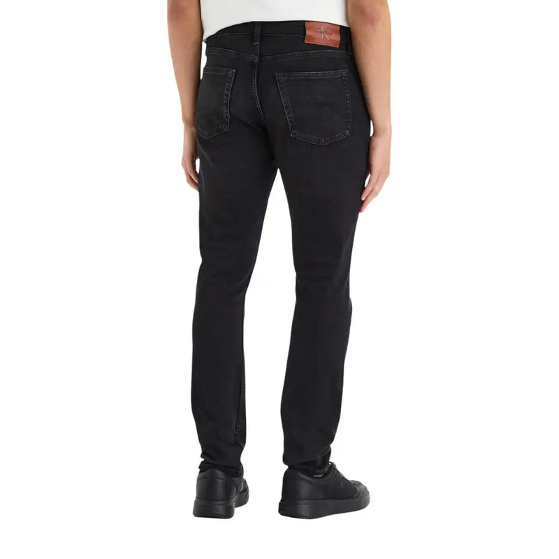 Calvin Klein Schwarze Herren-Jeans aus Baumwoll-Denim, schmal geschnitten mit dezenter Waschung an den Oberschenkeln.