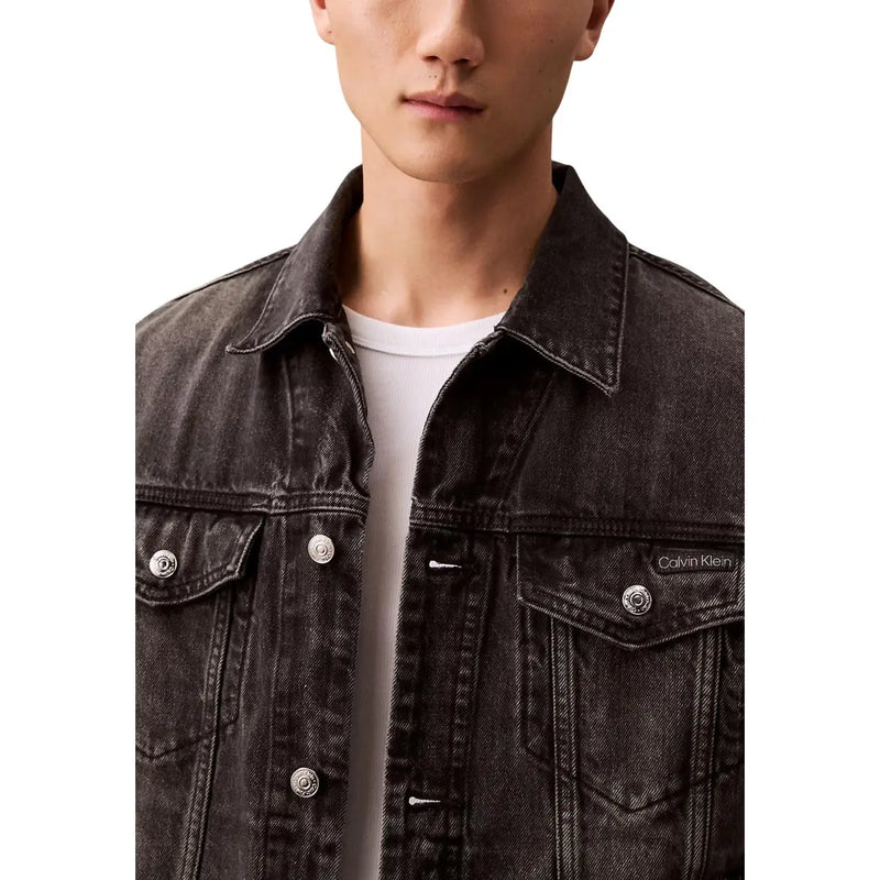 Schwarze Herren-Jeansjacke von Calvin Klein aus Baumwolle im Used-Look mit silbernen Knöpfen und Logo-Patch auf der linken Brust.