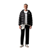 Schwarze Steppjacke mit Kapuze und weißem Calvin Klein Logo auf der Brust für Herren, dazu schwarze Baumwollhose