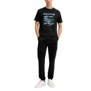 Schwarzer Calvin Klein t-shirt mit hellblauem, gestapeltem Kleen-Logo, kombiniert mit einer schwarzen Herbst-Winter-Baumwollmischhose