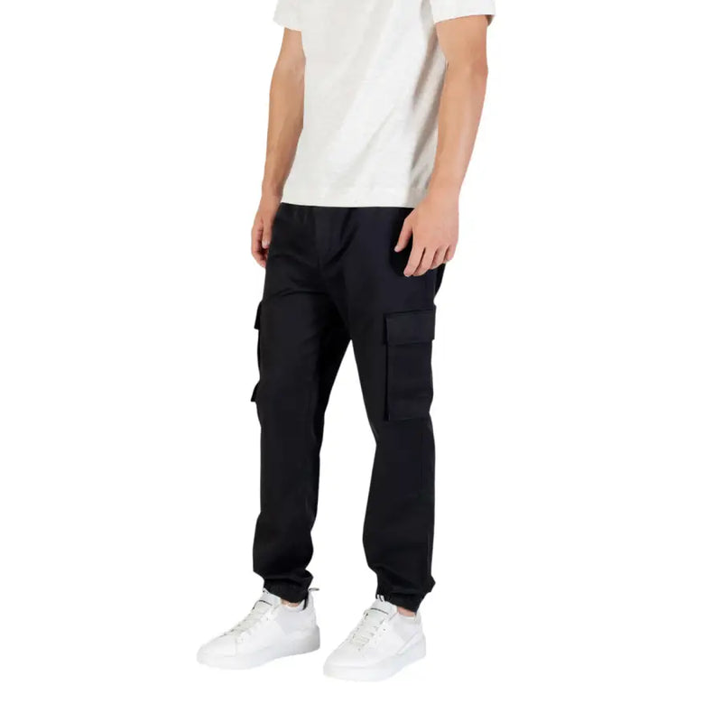Men’s black cargo joggers with white sneakers from Calvin Klein Jeans for fall winter style