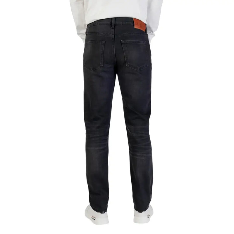 Schmale Passform bei dunkler Waschung Calvin Klein Baumwolljeans für Herren mit schwarzem Reißverschlussknopf und braunem Leder-Markenpatch am Bund