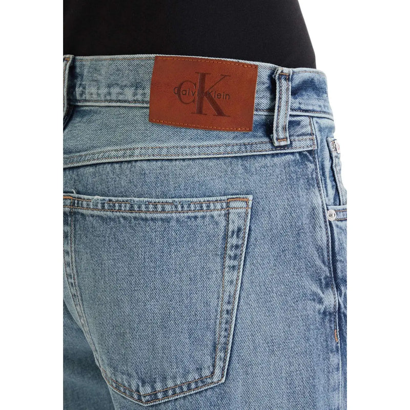 Light-wash denim jeans back view featuring brown leather Calvin Klein brand patch classic 100 cotton material