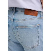 Rückansicht einer Calvin Klein Herren-Jeans aus blauem Baumwoll-Denim mit heller Waschung und braunem Leder-Markenpatch am Bund