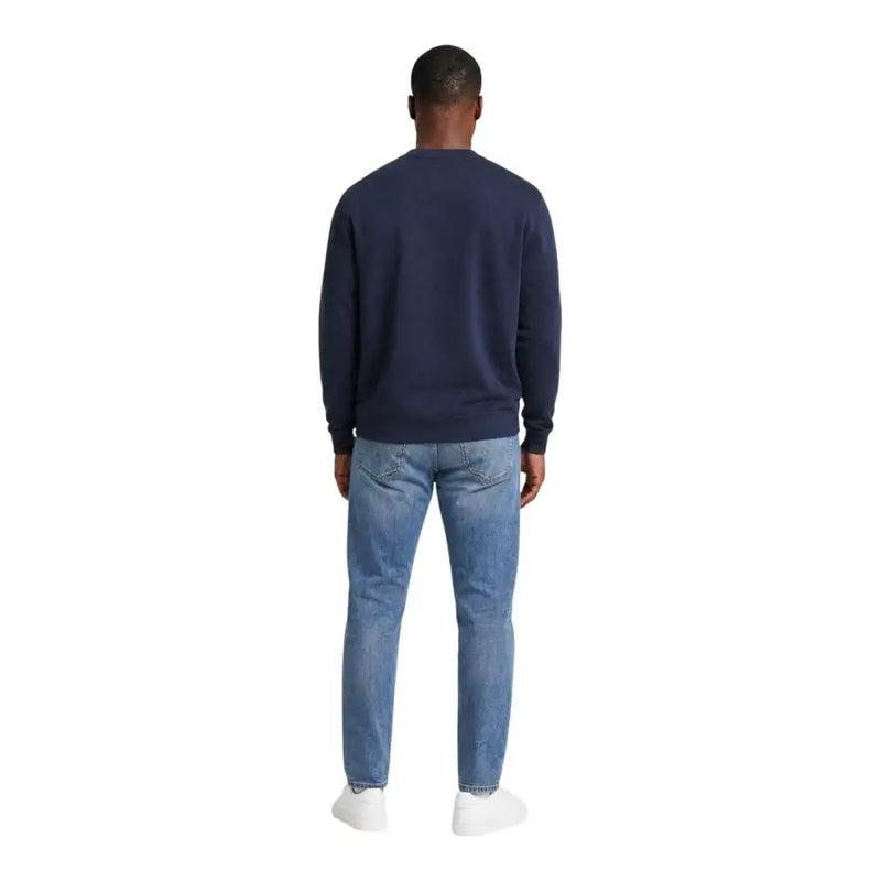 Calvin Klein Jeans Herren-Sweatshirt aus blauer Baumwolle mit Rundhalsausschnitt, kombiniert mit hellen Jeans für einen lässigen Look