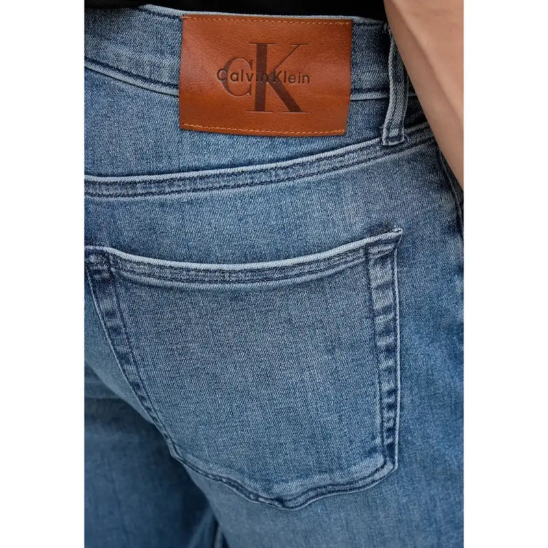 Rückansicht einer blauen Herren-Jeans aus Baumwoll-Denim mit Reißverschlusstasche und braunem Leder Calvin Klein Markenaufnäher