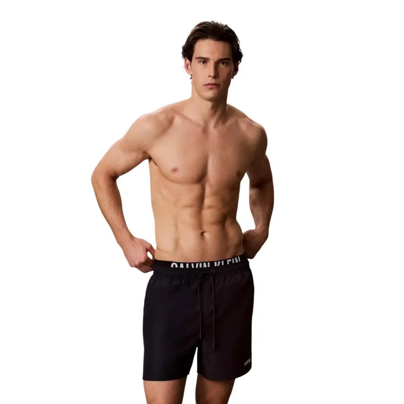Schwarze Calvin Klein Badehose mit weißem Logostreifen und Kordelzug im Bund, aus Polyester, Größe M