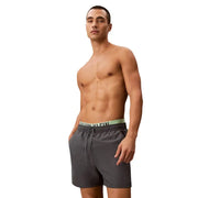 Calvin Klein Jeans Herren-Badeshorts aus grauem Polyester, Größe M, mit dunkelgrauem Rumpf und hellgrünem Logo am Bund.