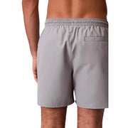 Calvin Klein Herren-Badeshorts aus grauem Polyester, Größe M, mit elastischem Bund und einer einzelnen Tasche, die Rückseite zeigt.