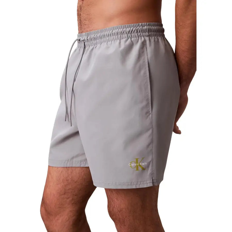 Calvin Klein Jeans graue Herren-Badeshorts aus Polyester, Größe M, mit dezentem goldenem Logo am Unterschenkel zum Schwimmen