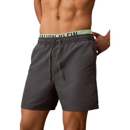 Calvin Klein Jeans men grey polyester swim shorts featuring dark grey trunks with light green waistband logo
