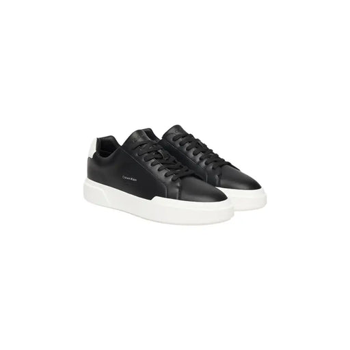 Calvin Klein Jeans Schwarze Herren-Sneaker aus Leder mit weißer Gummisohle und kontrastierender weißer Fersenlasche, von der Rückseite gesehen