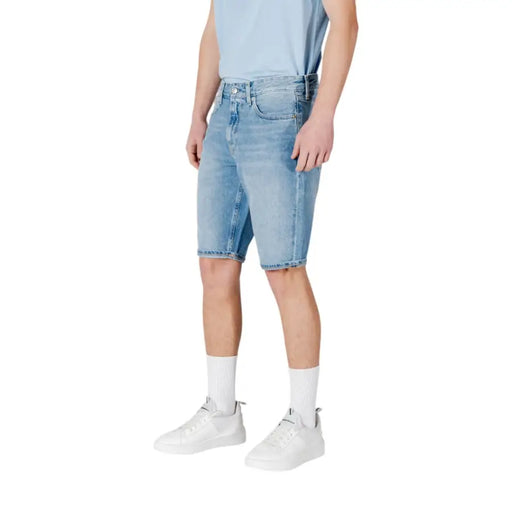 Light blue denim shorts with white socks and sneakers.