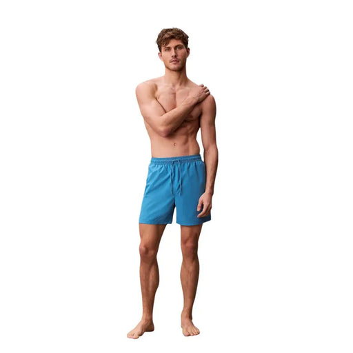 Calvin Klein Jeans men light blue polyester swim shorts featuring bright blue swim trunks with a drawstring waistband
