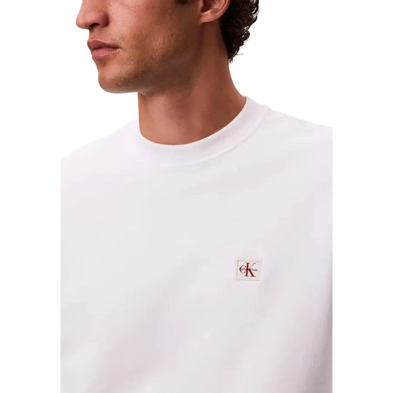 Calvin Klein Jeans Herren-Sweatshirt aus weißer Baumwolle mit Rundhalsausschnitt und kleinem roten und schwarzen Logo-Aufnäher auf der linken Brust
