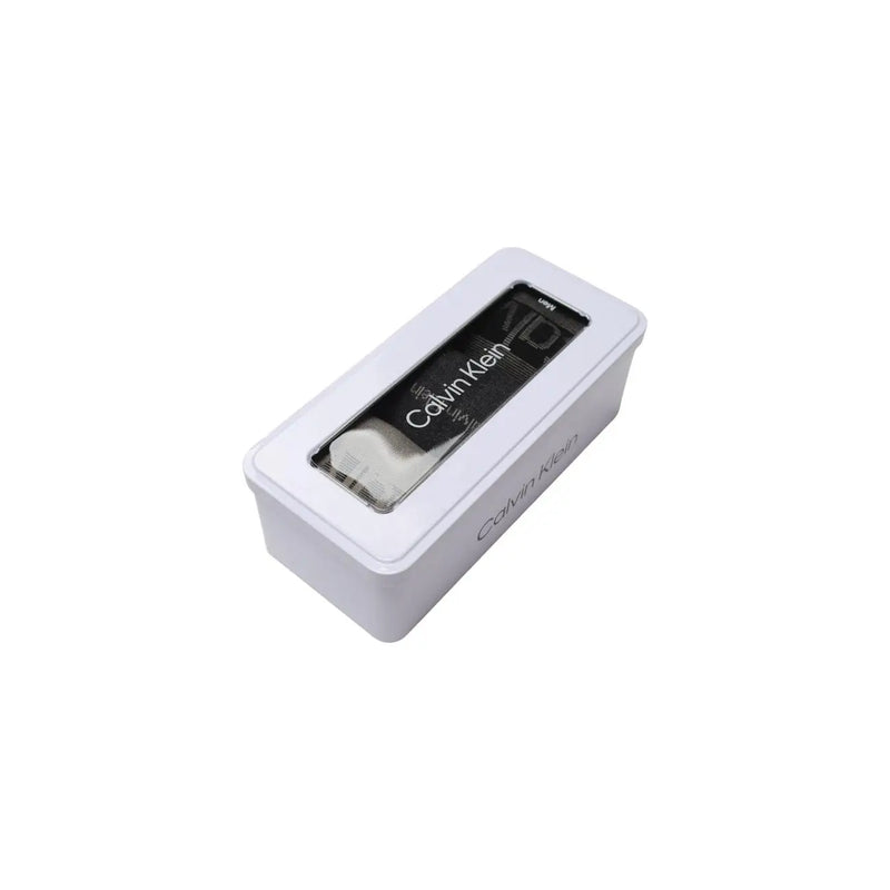 White calvin klein rectangular tin box with clear window displaying black and white cotton socks in beige gift box