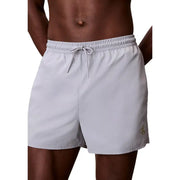 Light gray Calvin Klein Jeans men swimwear swim trunks with drawstring waistband and subtle gold logo on lower right leg