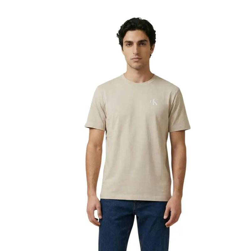 Beige Calvin Klein Jeans Männer t-shirt mit dezentem weißen Logo auf der linken Brust, lässiger Baumwollstoff