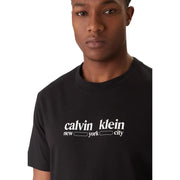 Schwarzes Baumwoll-T-Shirt von Calvin Klein Jeans für Herren mit weißem Calvin Klein New York City Logo auf der Brust und kurzen Ärmeln