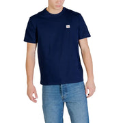 Marineblaues Calvin Klein Jeans Herren-T-Shirt aus Baumwolle mit kleinem weißen Logo-Patch auf der linken Brust im SS-Badge-30s-Jersey-Stil.