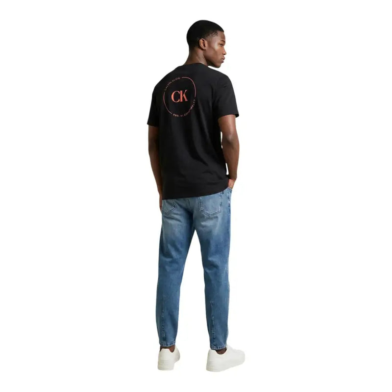 Rückseite schwarz Calvin Klein Jeans Männer t-shirt mit einem rosa-weißen kreisförmigen Logo auf der Rückseite